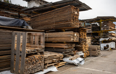 Stacks of wooden planks and boards stored at lumber warehouse for construction and carpentry use