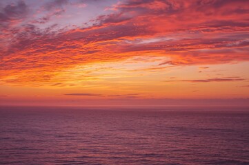 Obraz premium A stunning evening sky glowing with vibrant hues above the sea