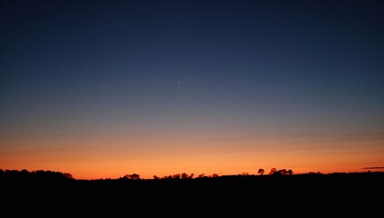Obraz premium The Sun Sets Beneath The Night Sky