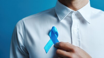 Man in white shirt pins blue ribbon to show awareness and support for a cause