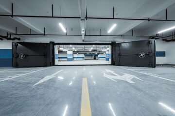 Wide open heavy steel doors in underground parking garage facility for safety and protection.