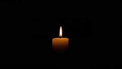 A single white candle flickers in the darkness, casting a gentle glow of hope