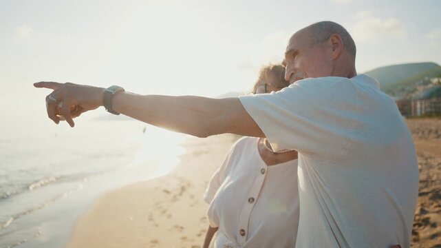 Happy senior couple embracing and enjoying a romantic moment on the beach during a beautiful sunset, celebrating a lifetime of love and companionship together during their golden years