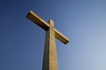 A stone Christian cross, with a blue sky in the background...2