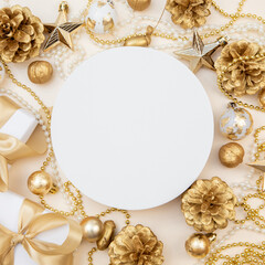 Round white board with golden Christmas decorations and gift boxes. Flat lay with copy space for text or logo.