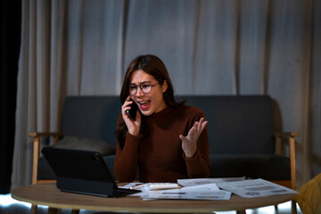 Stressed woman having an angry phone call working late