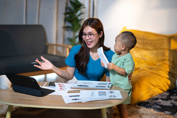 Working mother multitasking with baby while teleworking from home
