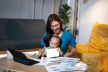 Asian mother working remotely with baby at home