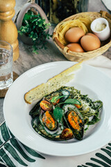 A delicious seafood dish of pasta, mussels, and herbs on a table