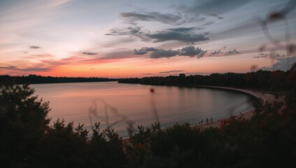 Perfect backdrop featuring a blurred lake scene with shallow focus, grain, and noise from extended exposure at dusk.