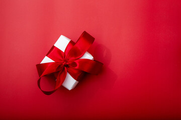 Minimal background with gift box and red ribbon. Perfect for cosmetics, fashion branding and holiday campaigns.