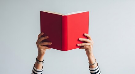 Person holding a red book with blank pages against a white background