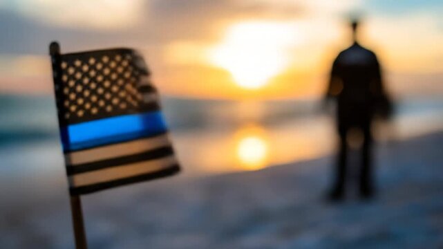 Back the blue flag on a beach with a silhouette of a person at sunset