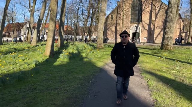 Hombre paseando por los jardines del beaterio en Brujas