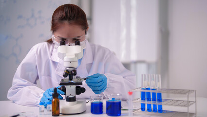 Asian female scientist uses microscope conducts research modern laboratory medical science discovery