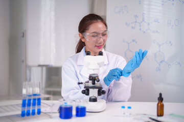Fototapeta premium Asian woman scientist laboratory preparation wearing safety goggles blue gloves ready for chemistry research experiment