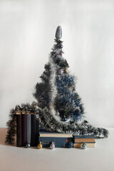 On the table are books, a Christmas tree, decorations and balls. Vertical frame.
