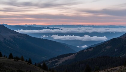 Obraz premium Majestic Mountain Landscape with Rolling Clouds and Vibrant Sunset Glow Over the Horizon
