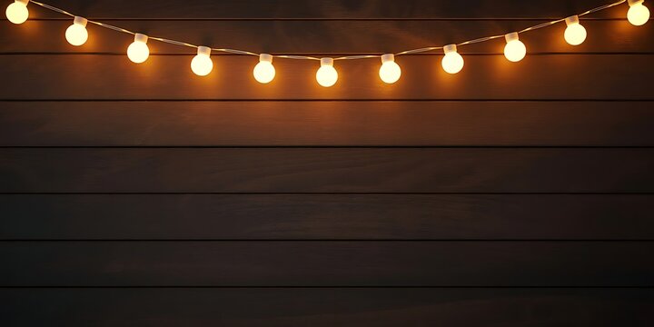String of warm fairy lights on a dark wooden background for decoration