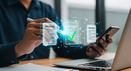 Man using stylus on virtual invoices on laptop screen and smartphone for digital document management and online payment approval process.