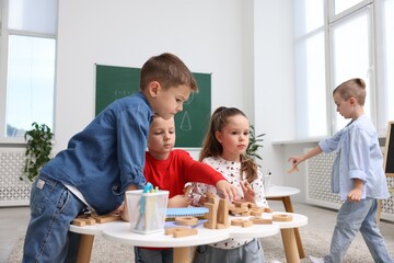 Cute children at white tables during lesson in elementary school