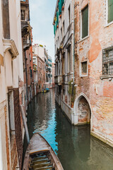 Canal with stone apartment buildings in Venice, Italy during summer day