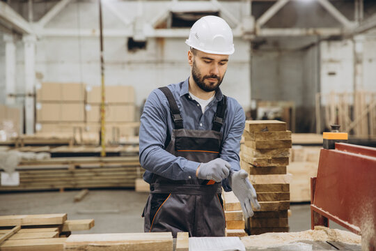 Carpenter wearing protective gloves in woodworking factory for modular building industry