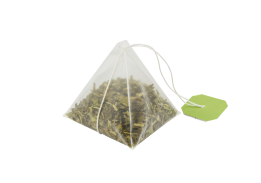 Pyramid tea bag with green tea isolated, herbal beverage in transparent bag with green label on no background PNG - Powered by Adobe