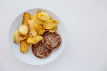 Hamburger e patate arrosto su piatto bianco