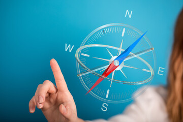 A conceptual image featuring a woman's hand interacting with a compass, representing guidance, direction, and navigation.