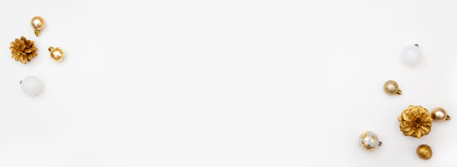 Minimal Christmas background with golden baubles and pine cones on white surface with copy space. Elegant composition for greetings and design.