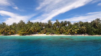Luxury resort photo of Maldives tropical paradise islands
in Indian Ocean with palm trees. Beautiful photography, 
coral reef, azure ocean, sky with clouds on horizon.