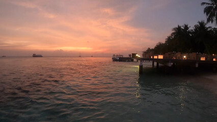 Luxury resort photo of Maldives tropical paradise islands in Indian Ocean at sunset with
hotel territory, palm trees. Beautiful evening photography, sky with clouds. 