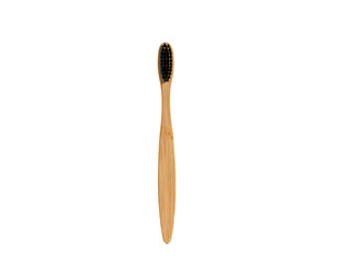 A wooden toothbrush with black bristles, displayed vertically against a dark, isolating background