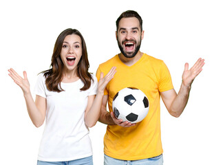 Couple in t-shirts, arms raised, jubilant; male holds soccer ball against black. Cheerful, excited, and sporty pose