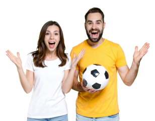 Couple in t-shirts, arms raised, jubilant; male holds soccer ball against black. Cheerful, excited, and sporty pose