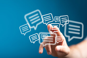 Hand interacting with digital chat bubbles. Represents messaging, social media, online conversations, networking, and the concept of global comm