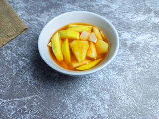 Asinan buah or pickled fruit in a bowl on a gray background. fresh Indonesian dessert spicy, sweet, and sour taste 