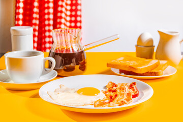 Fried egg with roasted bacon, black coffee, toasts on yellow background. Retro American breakfast. Hard shadow.