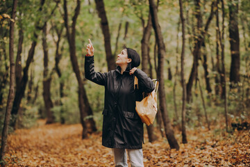 Woman with backpack hiking on footpath in autumn forest and relaxing outdoor.