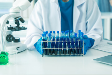 Scientists are experimenting with clear liquids in glass test tubes, using modern laboratory...