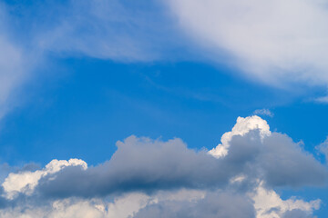 A serene blue sky with fluffy white clouds drifts above, creating an inviting atmosphere