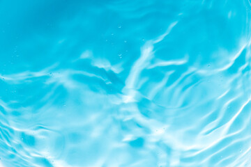 Close-up macro blue water wave texture,drops on water with circles on a blue background close up.