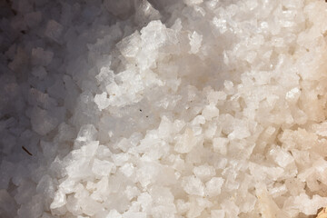 Sea salt, salt flakes. Wind mill sea salt production. The salt flats in July. Marsala, Trapani, Sicily, Italy. 