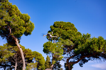 Drone flying against the sky and trees