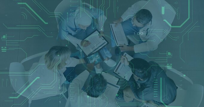 Collaborating medical staff reviewing charts and tablets at hospital glass table, with stethoscopes - Powered by Adobe