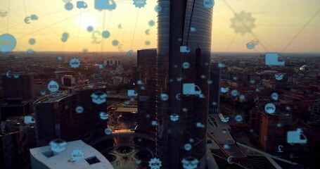 Bathing twin cylindrical glass skyscrapers in orange sunset, with floating digital commerce icons
