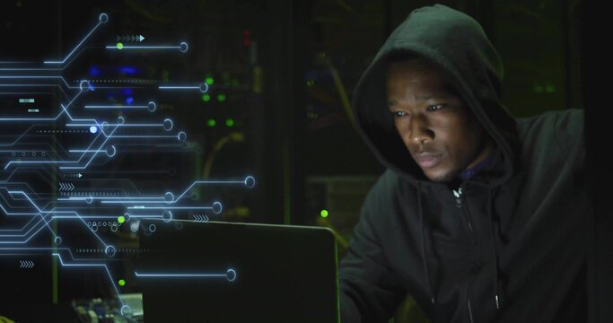 Operating laptop, adult male hacking data beside blinking server racks in data center, copy space