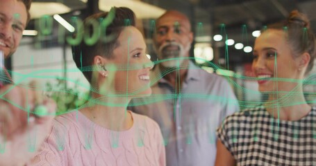 Four professionals studying green waveforms on glass partition in office, using dry-erase marker