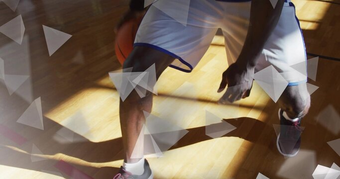 Mature basketball player dribbling basketball on gym court with court lines, triangular overlays